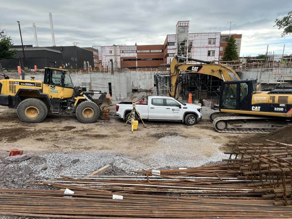 Chantier de construction avec excavatrice, bulldozer et camion à l'avant-plan.