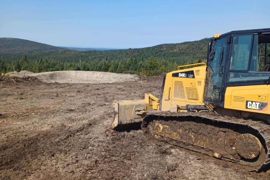 Bulldozer jaune en action pour nivellement du terrain.
